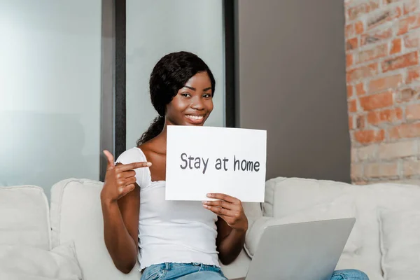 Африканська Американська Фрилансер Вказує Плакат Залишаючись Вдома Пишучи Посміхаючись Дивлячись — стокове фото