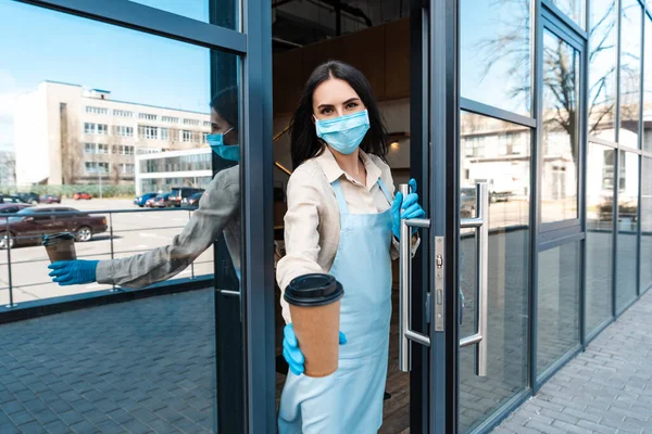 Cafe Eigenaar Medisch Masker Buurt Deur Tonen Wegwerp Kopje Koffie — Stockfoto