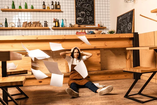 Masanın Yanında Gözleri Kapalı Yerde Kağıtları Olan Stresli Bir Kafe — Stok fotoğraf