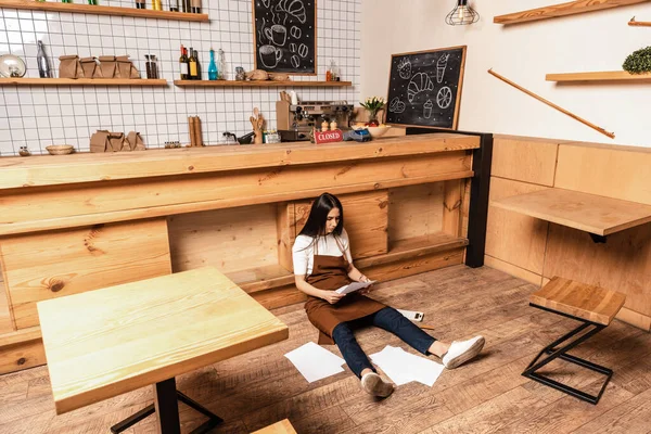 Cafébesitzer Schaut Sich Unterlagen Tisch Auf Dem Fußboden — Stockfoto