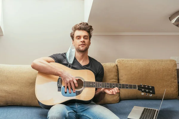 Handsome Man Medical Mask Ear Playing Guitar While Sitting Sofa — Stock Photo, Image