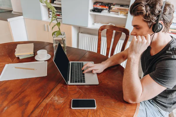 Magas Látószögű Kilátás Férfi Headset Dolgozik Otthon Közelében Laptop Okostelefon — Stock Fotó