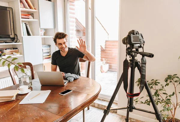 Alegre Vlogger Tejiendo Agitando Mano Mientras Mira Cámara Digital Trípode —  Fotos de Stock