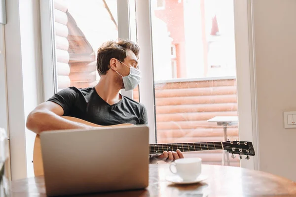 Young Man Medical Mask Holding Guitar Looking Away While Sitting — Stock Photo, Image