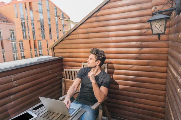 Muda Pria Tampan Melihat Pergi Sambil Duduk Balkon Dekat Laptop — Stok Foto