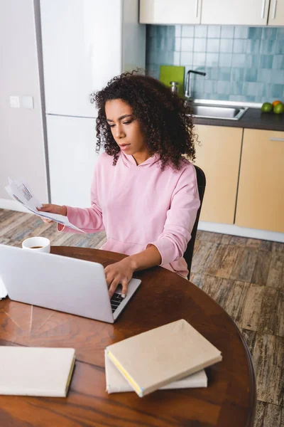 Foco Seletivo Encaracolado Freelancer Afro Americano Usando Laptop Segurando Documentos — Fotografia de Stock