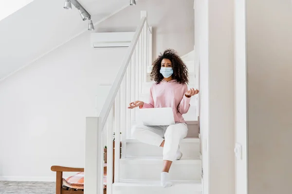 Confuso Freelancer Afroamericano Máscara Médica Sentado Las Escaleras Mostrando Gesto — Foto de Stock