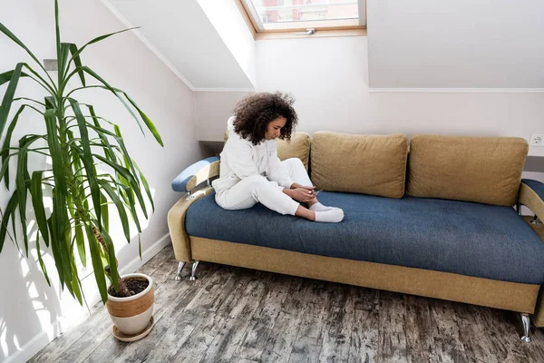 Menarik African American Gadis Menggunakan Smartphone Dan Duduk Sofa Rumah — Stok Foto