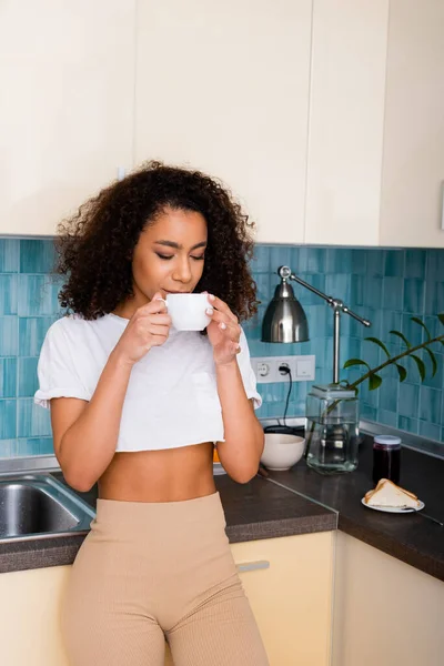 Curly African American Girl Drinking Coffee While Holding Cup — Stock Photo, Image