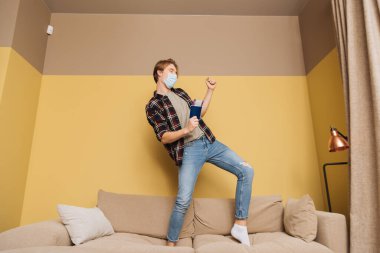 Tıbbi maskeli heyecanlı adam elinde uçak bileti olan bir adam. Karantina sona erdi. 