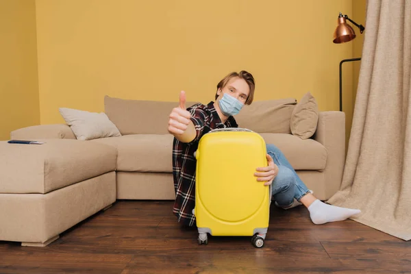 Selective Focus Man Medical Mask Sitting Floor Baggage Showing Thumb — Stock Photo, Image