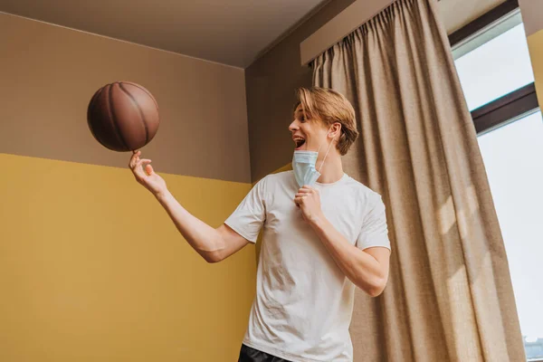 Excited Man Medical Mask Spinning Basketball Finger Home — Stock Photo, Image