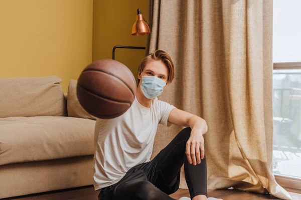 Medikal Maskeli Bir Adamın Basketbol Tutarken Seçilmiş Odağı — Stok fotoğraf