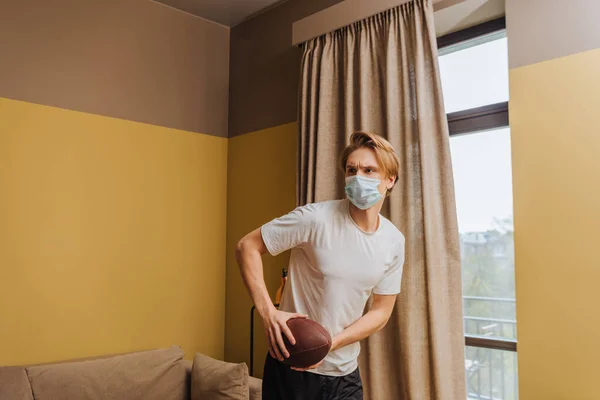 Young Man Medical Mask Holding American Football Living Room — Stock Photo, Image