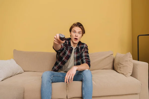 Selective Focus Surprised Man Holding Remote Controller Sitting Sofa End — Stock Photo, Image