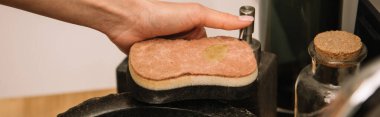 cropped view of woman holding sponge near sink, horizontal image clipart