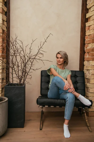 Beautiful Young Woman Looking Away While Sitting Armchair Home — Stock Photo, Image