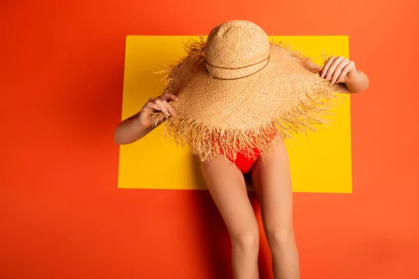 Top View Young Woman Swimsuit Touching Straw Hat Orange — стоковое фото