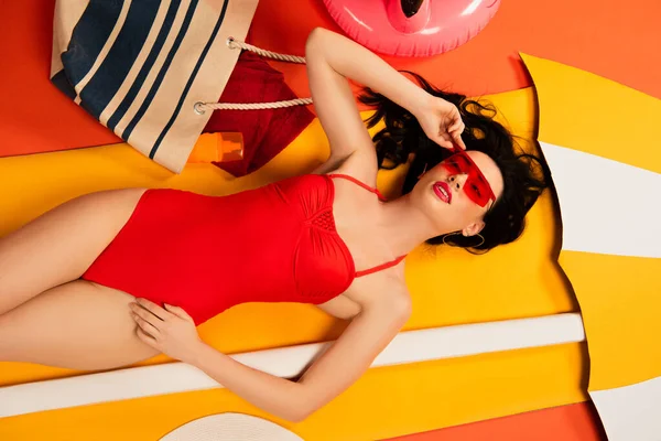 Top View Beautiful Woman Sunglasses Swimsuit Touching Cap Lying Orange — Stock Photo, Image