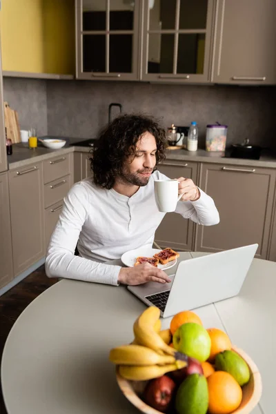 Foco Seletivo Freelancer Beber Café Perto Laptop Torradas Frutas Frescas — Fotografia de Stock