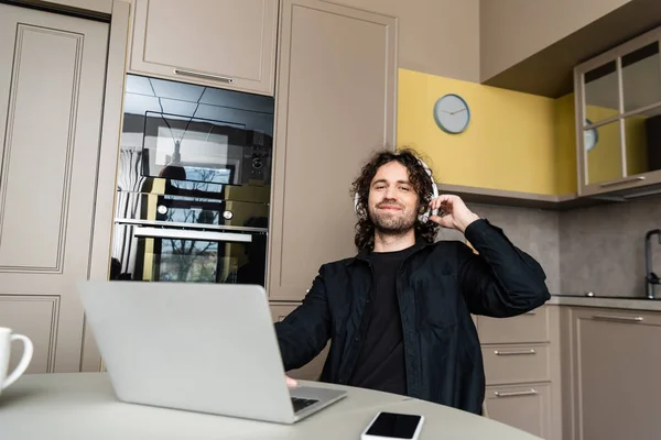 Sonriendo Freelance Auriculares Inalámbricos Mirando Cámara Cerca Computadora Portátil Teléfono —  Fotos de Stock