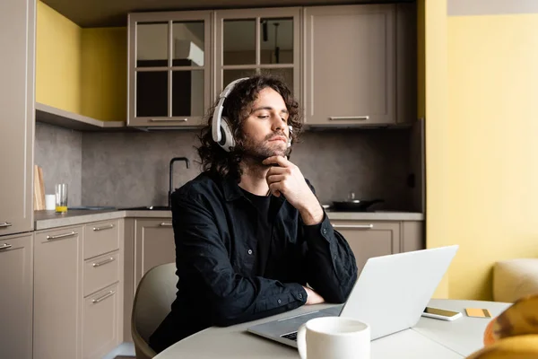 Kulaklıklı Adamın Mutfaktaki Webinar Sırasında Dizüstü Bilgisayara Baktığı Seçmeli Bir — Stok fotoğraf