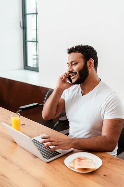 Enfoque Selectivo Barbudo Afroamericano Freelancer Hablando Teléfono Inteligente Cerca Computadora — Foto de Stock