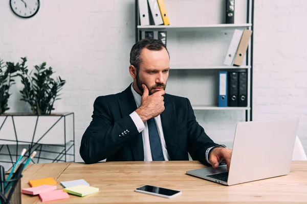 Portrait d'un homme d'affaires concentré travaillant sur un ordinateur portable au travail au bureau — Photo de stock