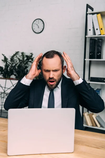 Portrait of stressed businessman at workplace with laptop in office — Stock Photo