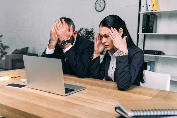 Vista parcial de los empresarios con exceso de trabajo en el lugar de trabajo con ordenador portátil en la oficina - foto de stock