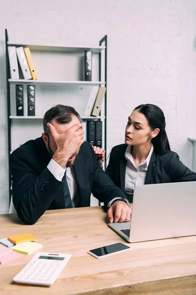 Overworked businessman and business colleague at workplace with laptop in office — Stock Photo