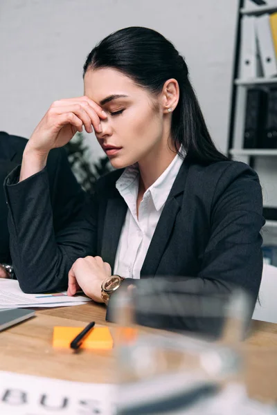 Selektiver Fokus müder Geschäftsfrau im Anzug am Arbeitsplatz im Büro — Stockfoto