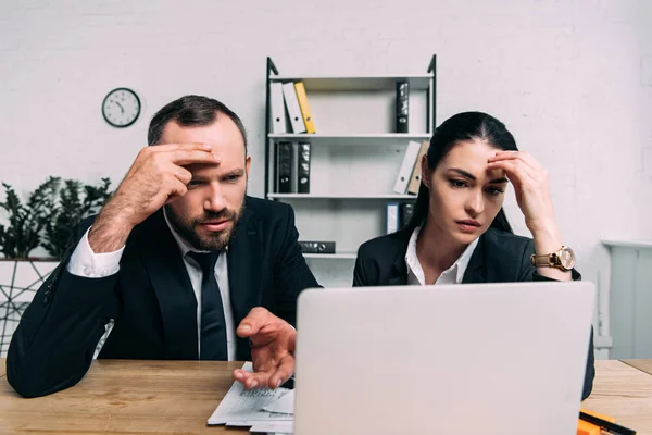 Retrato de gente de negocios cansada mirando la pantalla del ordenador portátil en el lugar de trabajo en la oficina - foto de stock