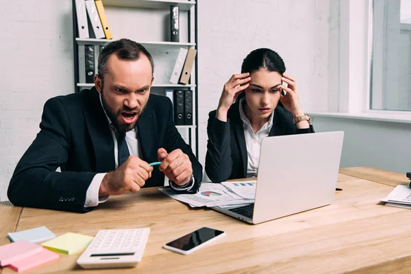 Gente de negocios estresada y sobrecargada de trabajo con documentos y computadora portátil en la oficina - foto de stock