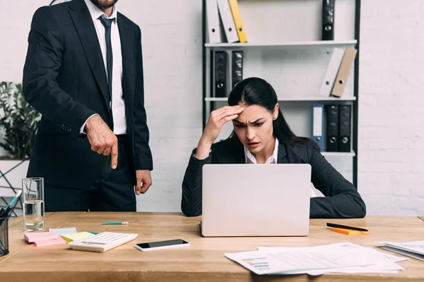 Colpo ritagliato di donna d'affari stressata e collega sul posto di lavoro con computer portatile in ufficio — Foto stock