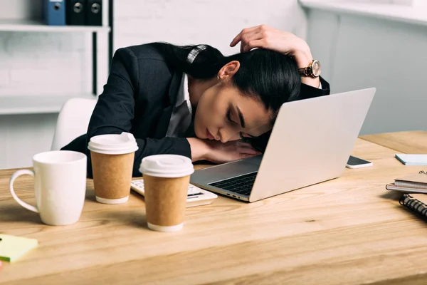 Donna d'affari oberata di lavoro che dorme sul posto di lavoro con computer portatile e caffè per andare in ufficio — Foto stock