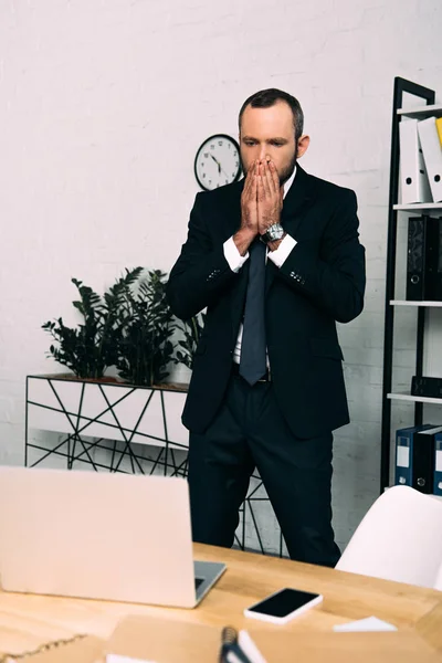 Homme d'affaires stressé en costume debout sur le lieu de travail dans le bureau — Photo de stock