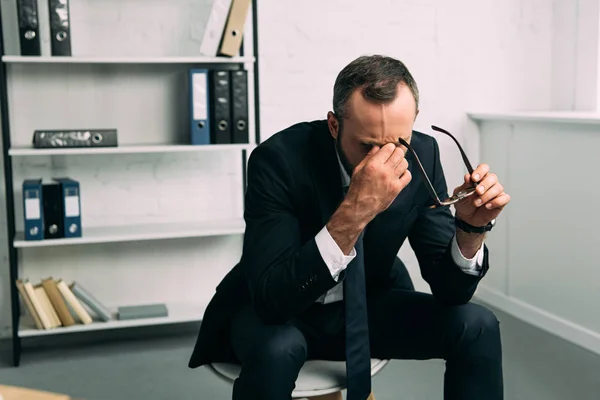 Портрет перевантажений бізнесмен в костюмі з окулярів в офісі — стокове фото