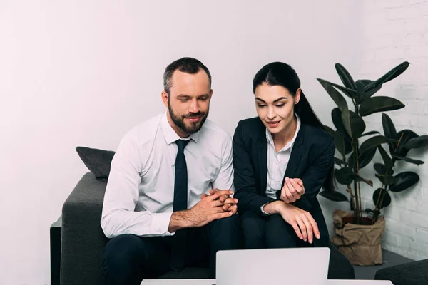 Retrato de colegas de negócios sorridentes usando laptop juntos na mesa de café no escritório — Fotografia de Stock