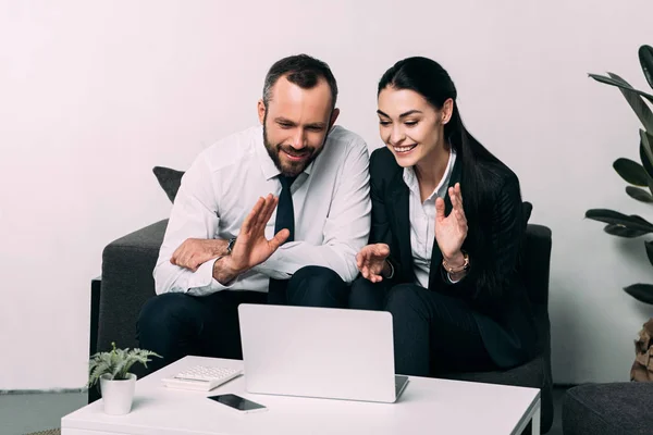 Portrait de collègues souriants ayant un appel vidéo à la table basse dans le bureau — Photo de stock