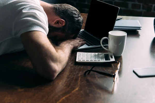 Freelancer cansado remoto deitado na mesa com laptop na cozinha em casa — Fotografia de Stock