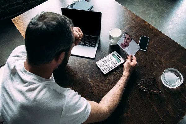 High angle view of man looking at photo of ex-girlfriend — Stock Photo