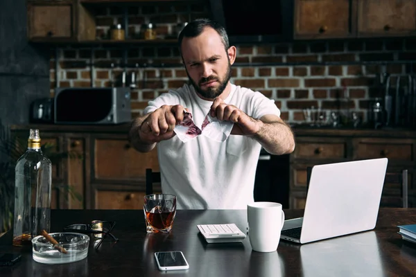 Angry young man tearing photo of ex-girlfriend — Stock Photo