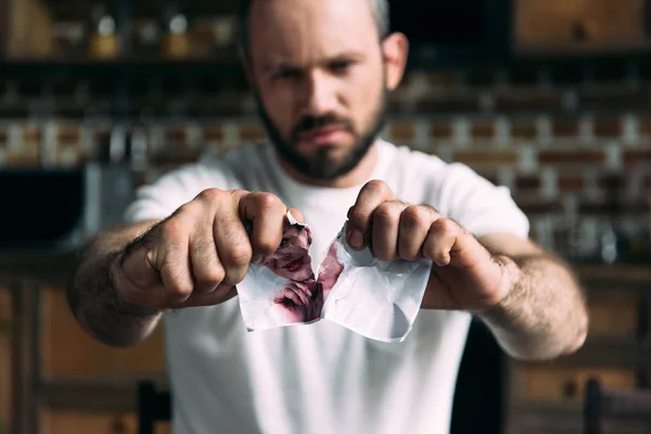 Close-up shot of angry young man tearing photo of ex-girlfriend — Stock Photo