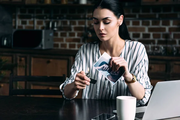 Solitario joven mujer quemando tarjeta de fotos de ex-novio - foto de stock