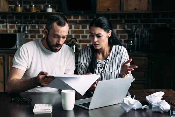 Husband and wife having quarrel while counting bills together at home — Stock Photo
