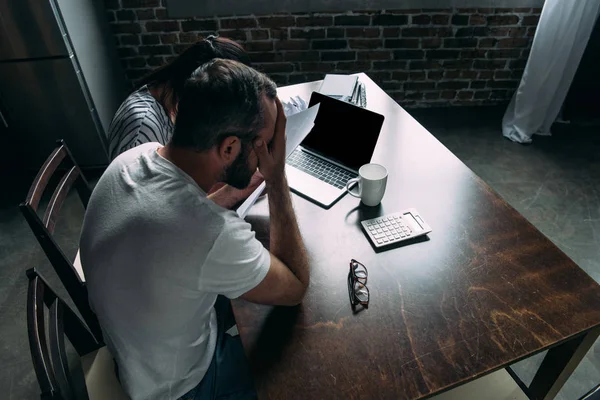 Vista ad alto angolo di depresso giovane coppia contare le fatture insieme — Foto stock