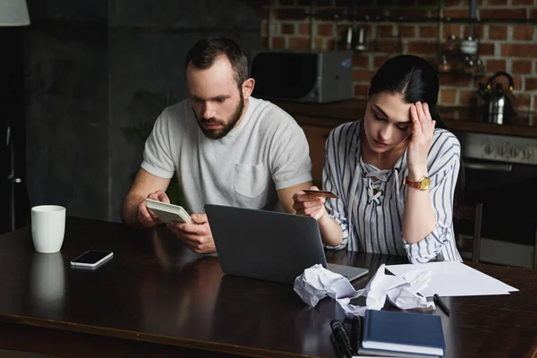 Jovem casal estressado contando impostos e contas com laptop e calculadora — Fotografia de Stock