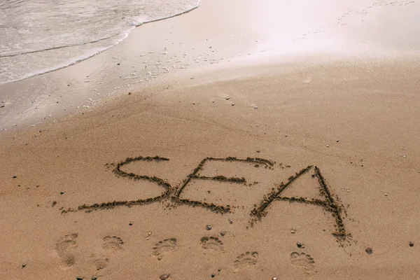 Summer beach with sea lettering on sand — Stock Photo