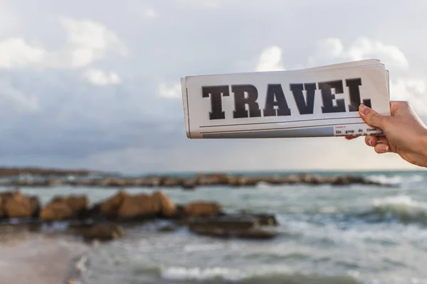 Abgeschnittene Ansicht einer Frau, die eine Reisezeitung in der Nähe des Meeres hält — Stockfoto